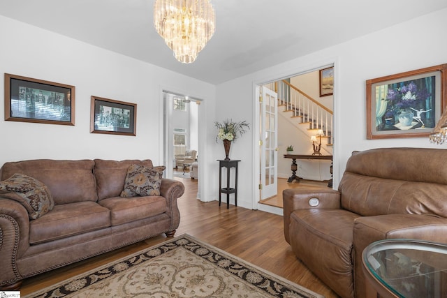 living room with hardwood / wood-style floors and a notable chandelier