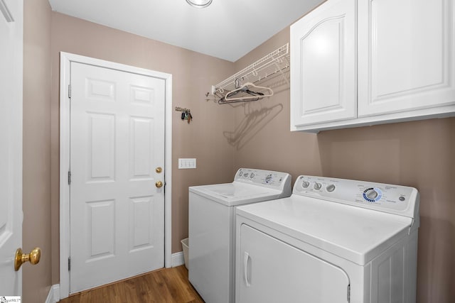 laundry room featuring cabinets, separate washer and dryer, and dark wood-type flooring