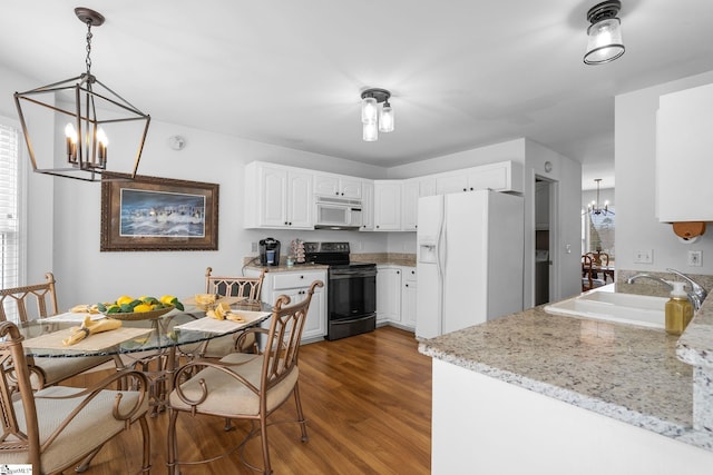 kitchen featuring sink, light stone counters, a notable chandelier, white appliances, and white cabinets