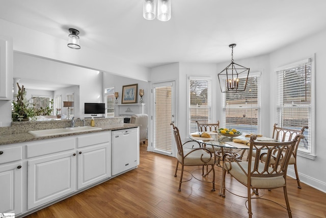 dining space featuring sink, a notable chandelier, and light hardwood / wood-style floors