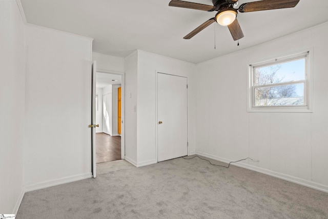 unfurnished bedroom with ceiling fan, light colored carpet, and a closet