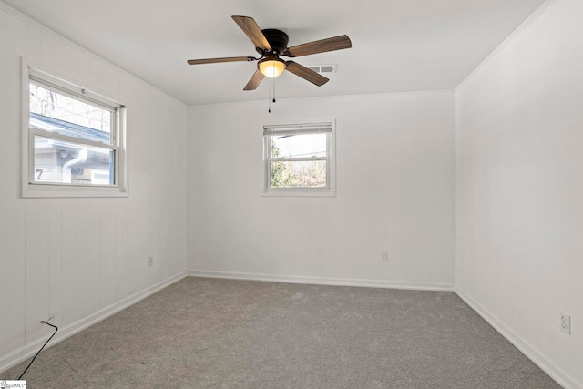 carpeted spare room with a wealth of natural light and ceiling fan