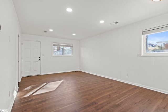 spare room with plenty of natural light and dark wood-type flooring