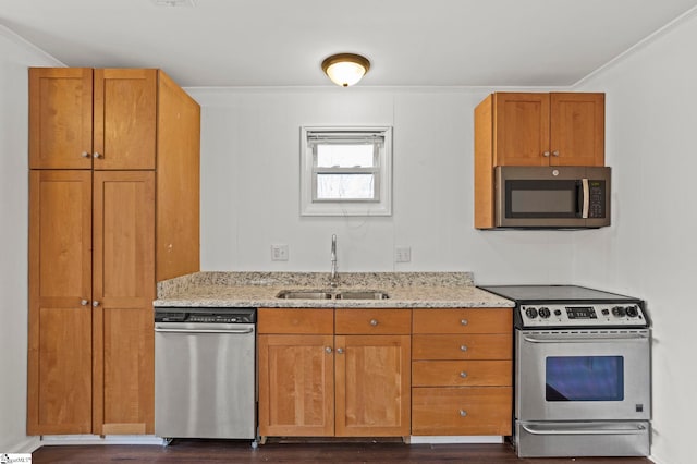 kitchen featuring stainless steel appliances, ornamental molding, sink, and light stone counters