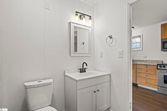 bathroom featuring vanity, hardwood / wood-style floors, crown molding, and toilet