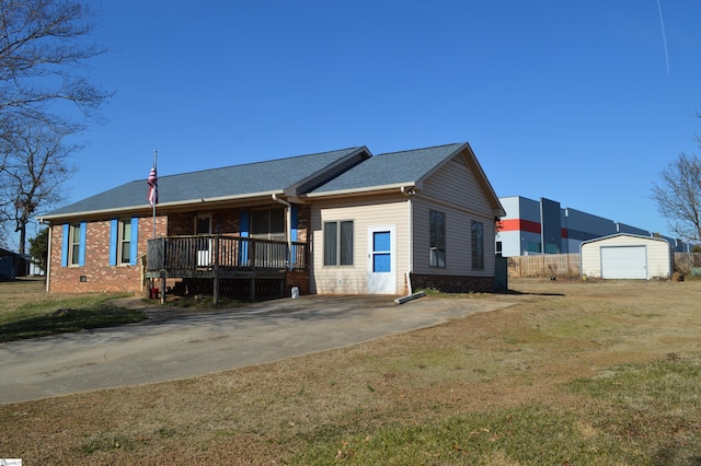 view of front of house featuring a garage, an outdoor structure, a porch, and a front lawn