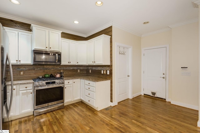 kitchen featuring decorative backsplash, stainless steel appliances, and white cabinets