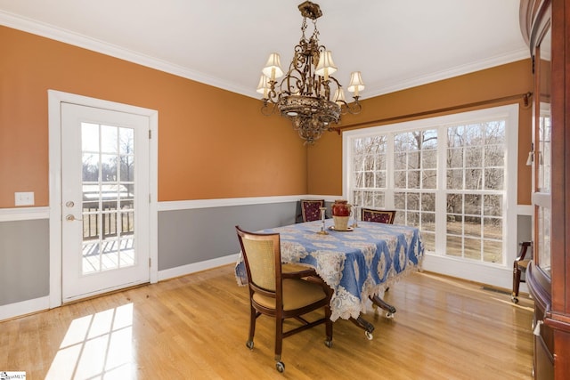 dining room with crown molding, a chandelier, and light wood-type flooring