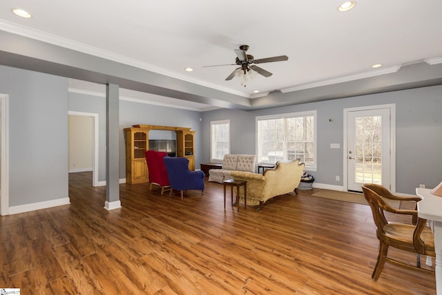 living room with hardwood / wood-style flooring, ornamental molding, and ceiling fan