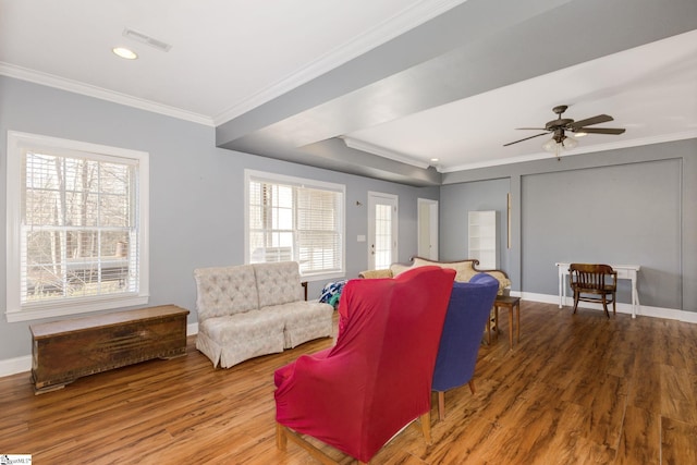 living room featuring ceiling fan, a healthy amount of sunlight, ornamental molding, and wood-type flooring