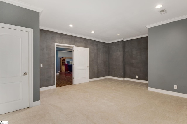 empty room featuring ornamental molding and light colored carpet