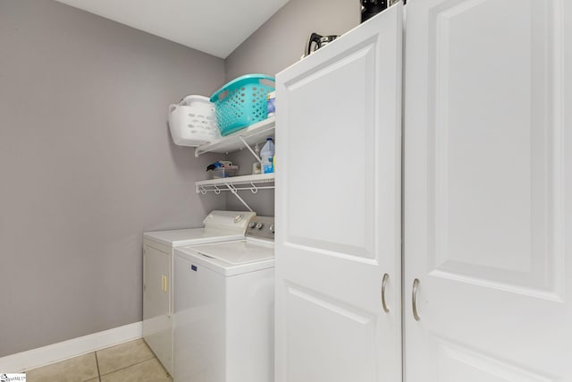 clothes washing area with light tile patterned flooring and independent washer and dryer