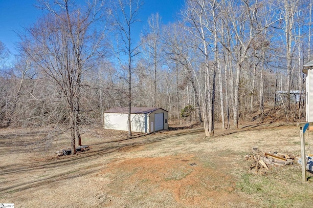 view of yard featuring a garage and a storage shed