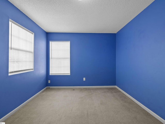 carpeted empty room with a textured ceiling