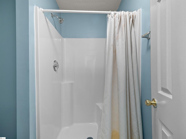 bathroom featuring a shower with curtain and a textured ceiling