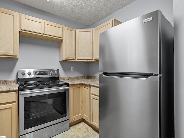 kitchen with light brown cabinets, a textured ceiling, and appliances with stainless steel finishes