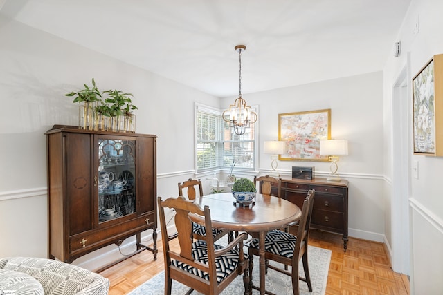 dining room with a chandelier and light parquet floors