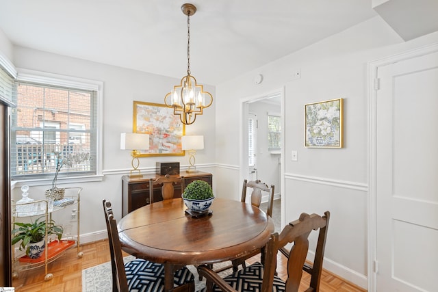 dining room featuring light parquet floors and an inviting chandelier