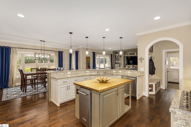 kitchen with butcher block counters, white cabinets, a kitchen island, decorative light fixtures, and kitchen peninsula