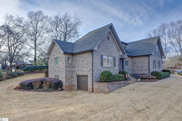 view of side of home with a garage and a lawn