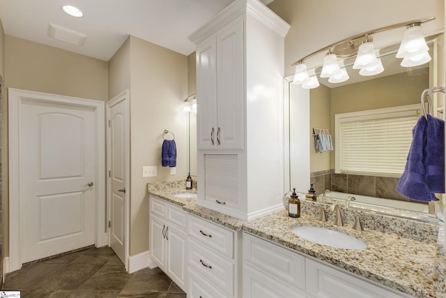 bathroom with vanity, a tub, and tile patterned floors