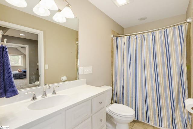 bathroom featuring tile patterned flooring, vanity, toilet, and walk in shower