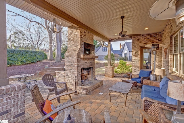 view of patio / terrace featuring an outdoor brick fireplace and ceiling fan