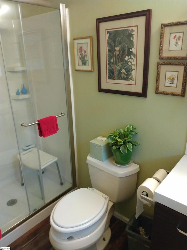 bathroom with hardwood / wood-style flooring, vanity, an enclosed shower, and toilet