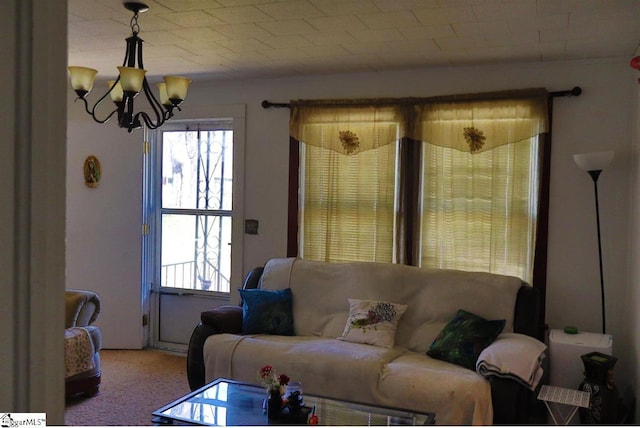 carpeted living room with an inviting chandelier