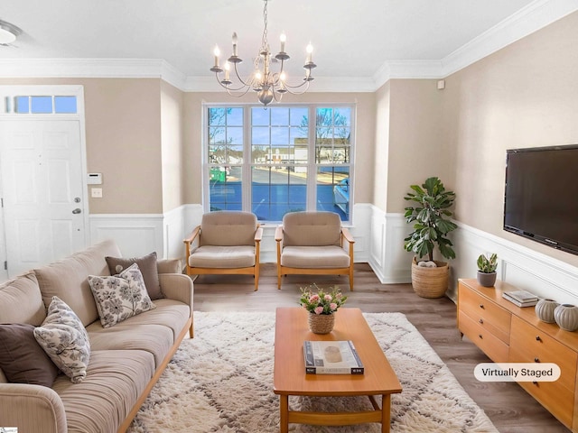 living room featuring an inviting chandelier, crown molding, and hardwood / wood-style flooring