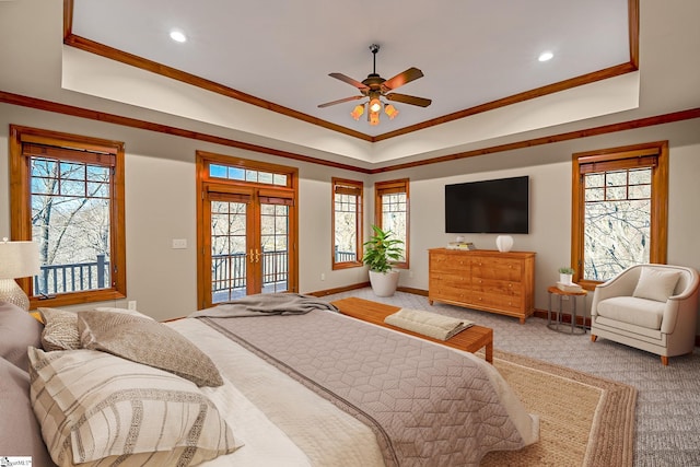 carpeted bedroom with ornamental molding, access to exterior, ceiling fan, a raised ceiling, and french doors