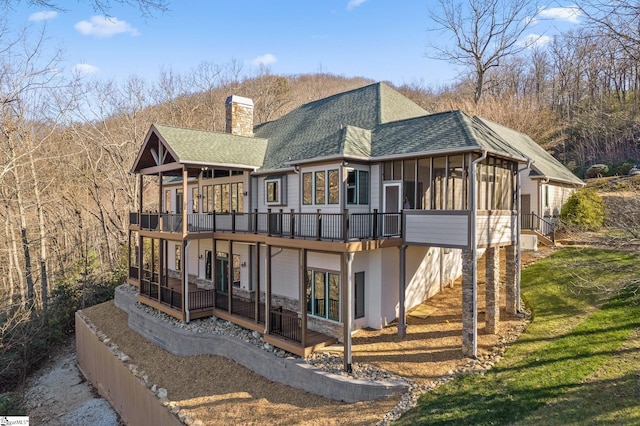 rear view of property featuring a sunroom and a yard