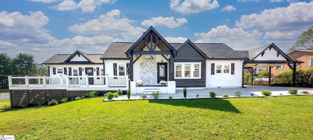 rear view of house with a carport, a deck, and a lawn