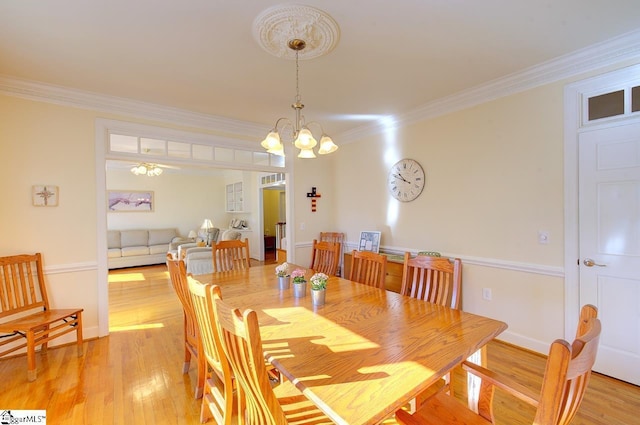 dining room featuring crown molding, an inviting chandelier, and light hardwood / wood-style flooring