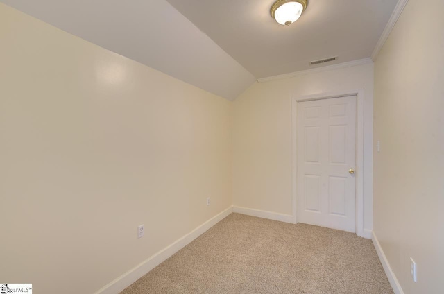 carpeted spare room with ornamental molding and lofted ceiling