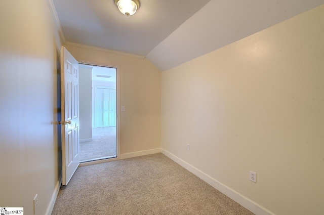 unfurnished room featuring crown molding, vaulted ceiling, and light colored carpet