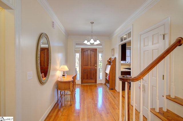 foyer with crown molding, an inviting chandelier, and light hardwood / wood-style floors