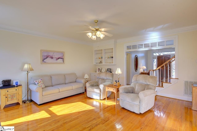 living room featuring hardwood / wood-style floors, crown molding, built in shelves, and ceiling fan