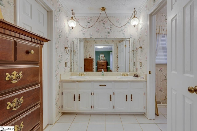 bathroom with tile patterned flooring, ornamental molding, vanity, and a textured ceiling