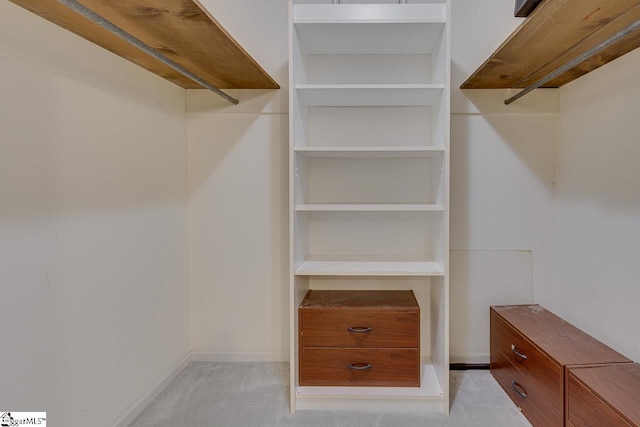 walk in closet featuring light colored carpet