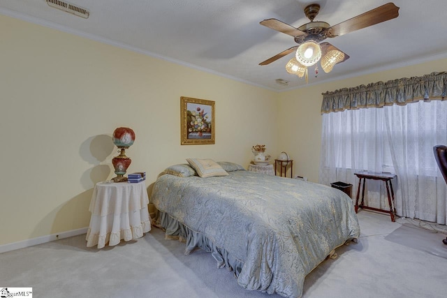 carpeted bedroom with ornamental molding and ceiling fan