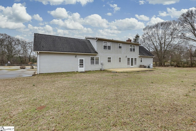 back of house featuring a deck and a lawn