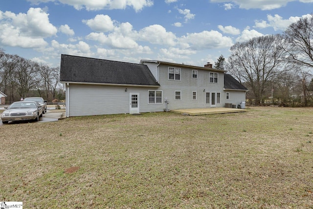 back of house with a wooden deck and a lawn