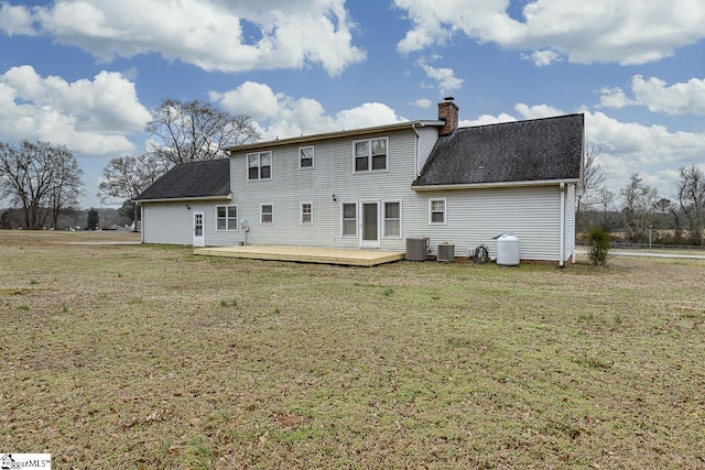 rear view of house featuring a wooden deck, a yard, and central AC