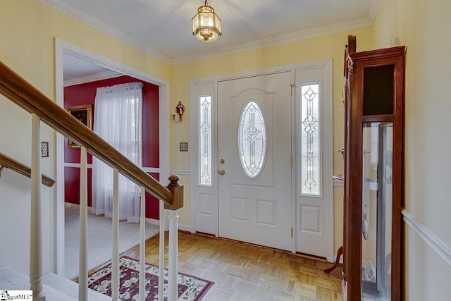 entryway featuring ornamental molding and light parquet flooring