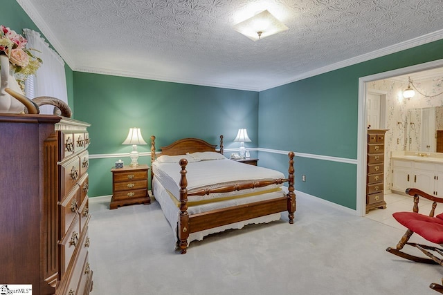 carpeted bedroom with ensuite bathroom, ornamental molding, and a textured ceiling