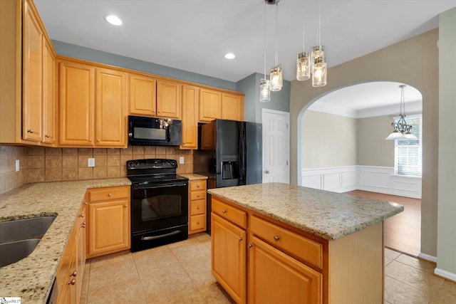 kitchen with light tile patterned floors, decorative backsplash, black appliances, and a center island