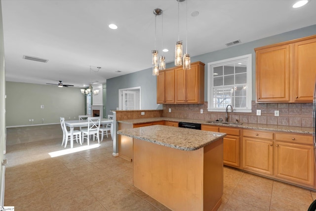 kitchen featuring tasteful backsplash, a center island, sink, and decorative light fixtures