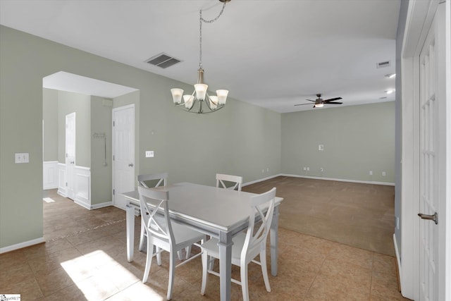 dining space with ceiling fan with notable chandelier and light tile patterned floors