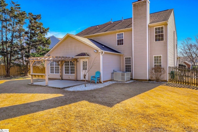 back of property with cooling unit, a pergola, a patio area, and a lawn